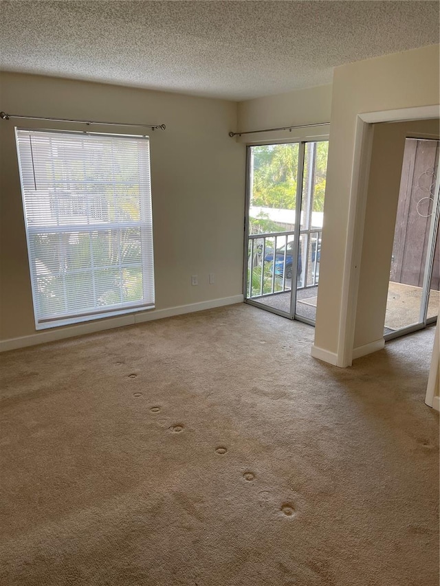 empty room with a textured ceiling and carpet flooring