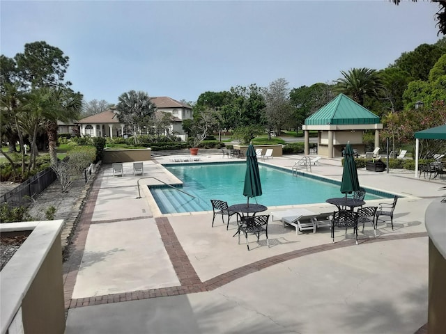 community pool featuring a patio and fence