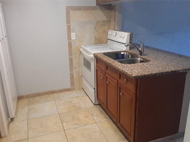 kitchen featuring light tile patterned floors, brown cabinetry, stone counters, a sink, and white range with electric stovetop