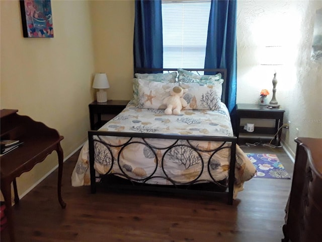 bedroom featuring baseboards and wood finished floors