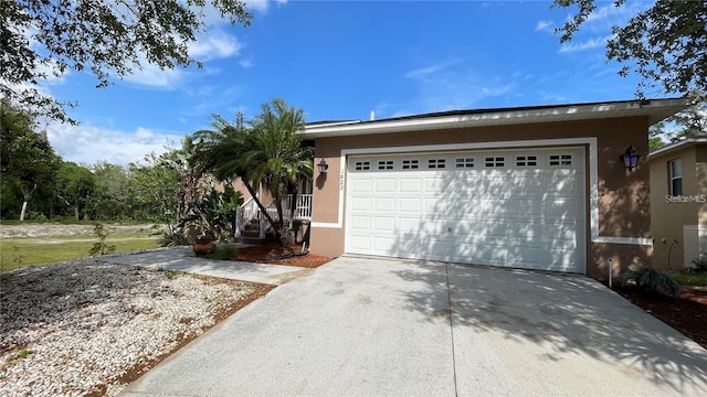 view of front of home with a garage, driveway, and stucco siding