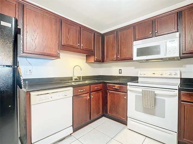 kitchen with light tile floors, white appliances, and sink