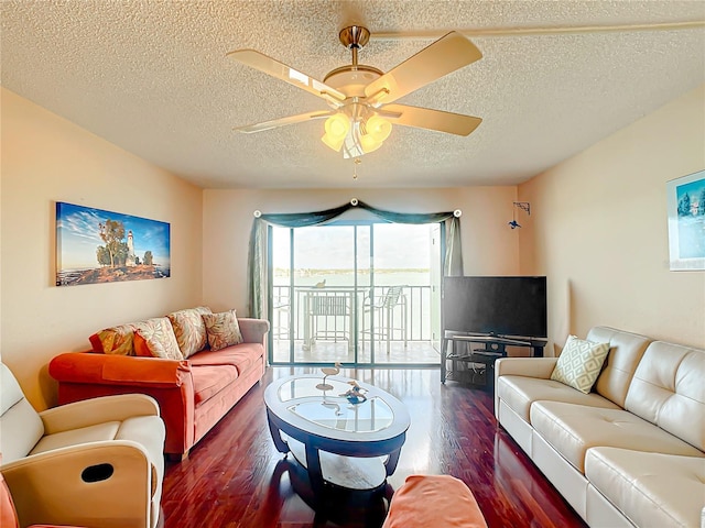 living room featuring ceiling fan, a textured ceiling, and dark hardwood / wood-style flooring