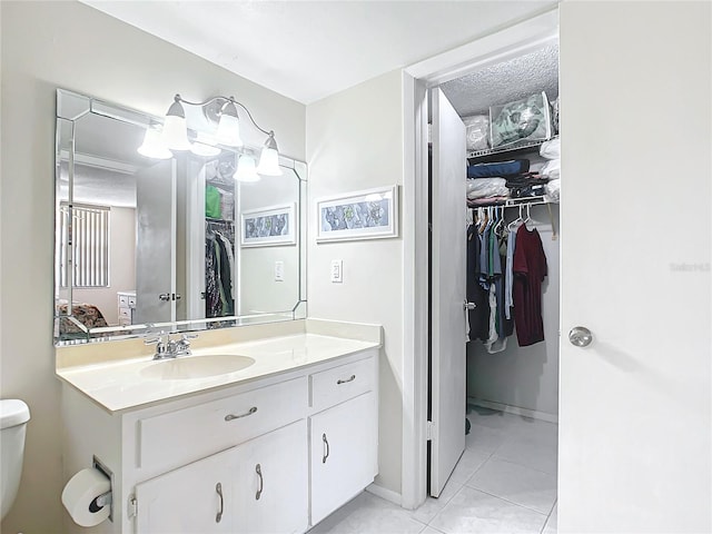 bathroom with toilet, tile floors, and large vanity