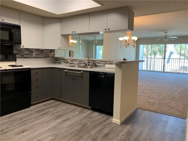 kitchen with ceiling fan with notable chandelier, black appliances, sink, and light hardwood / wood-style flooring