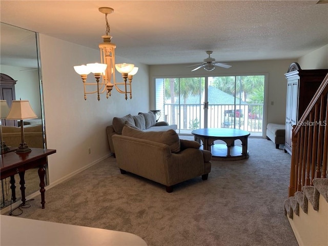 carpeted living room featuring a textured ceiling, ceiling fan with notable chandelier, and a healthy amount of sunlight