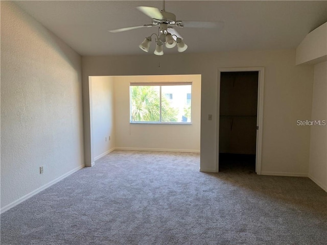 unfurnished bedroom with a closet, a walk in closet, ceiling fan, and light colored carpet