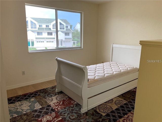 bedroom with dark wood-type flooring