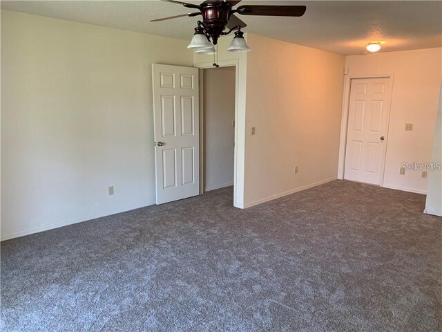 unfurnished room featuring ceiling fan and dark colored carpet