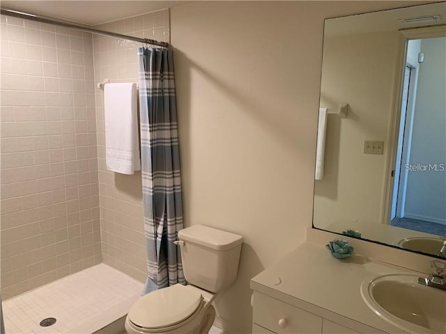 bathroom featuring toilet, vanity, and a shower with shower curtain