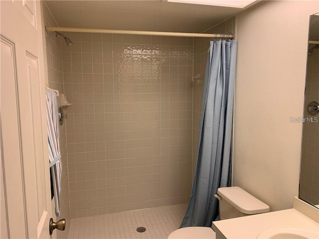 bathroom featuring toilet and a shower with shower curtain