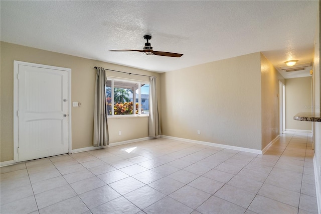 tiled spare room featuring ceiling fan and a textured ceiling