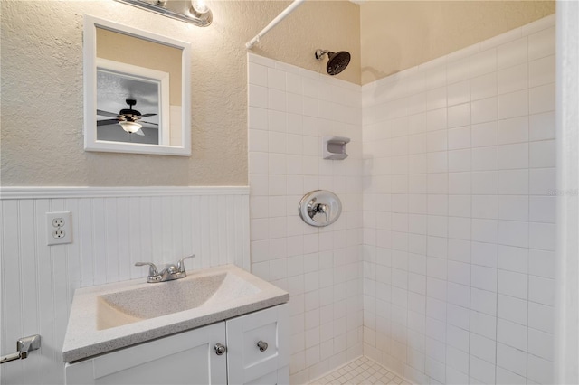 bathroom featuring tiled shower, ceiling fan, and vanity