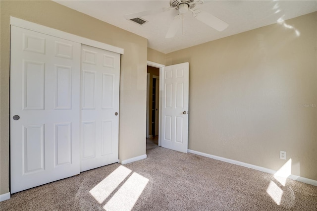 unfurnished bedroom featuring a closet, light colored carpet, and ceiling fan