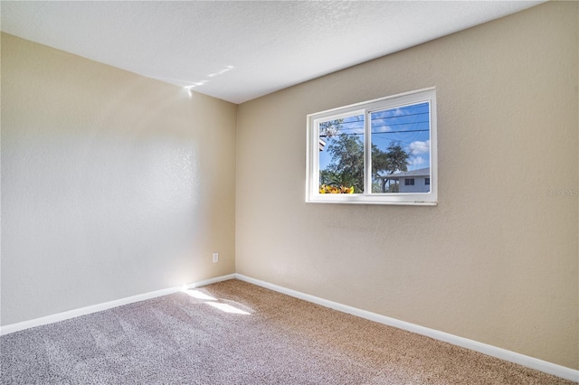 carpeted spare room featuring a textured ceiling