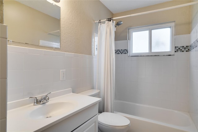 full bathroom with vanity, toilet, tile walls, and shower / bathtub combination with curtain