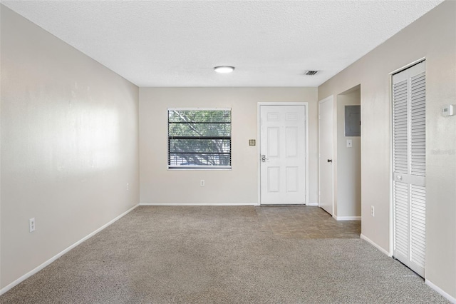 unfurnished room with light carpet and a textured ceiling