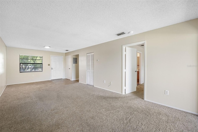 spare room with light carpet and a textured ceiling