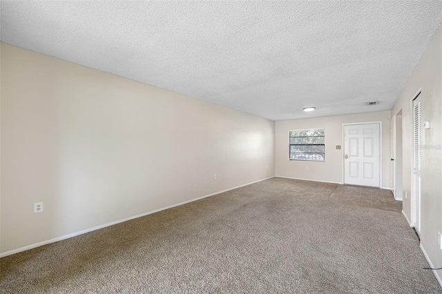 carpeted spare room with a textured ceiling