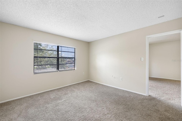 carpeted empty room featuring a textured ceiling