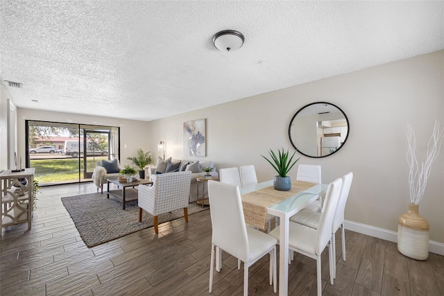 dining area with a textured ceiling and dark hardwood / wood-style floors