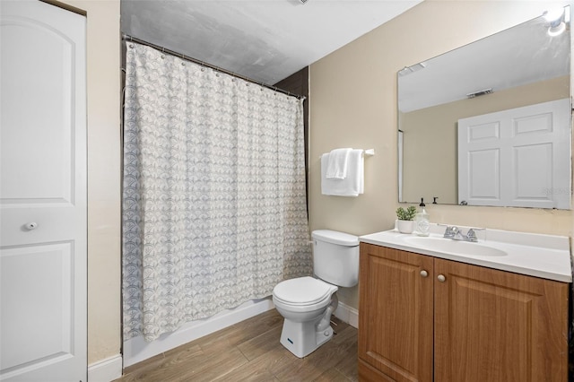 bathroom featuring vanity, toilet, curtained shower, and hardwood / wood-style floors