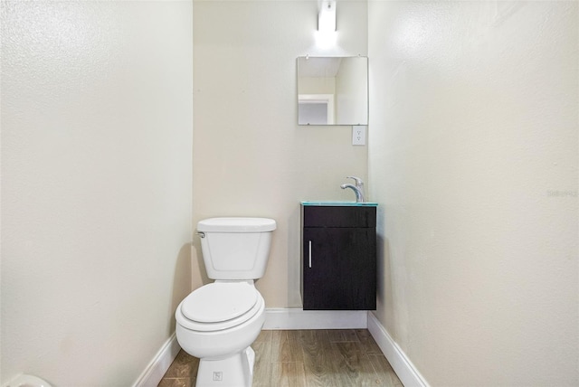 bathroom with wood-type flooring, toilet, and vanity