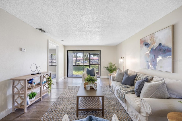 living room with hardwood / wood-style flooring and a textured ceiling