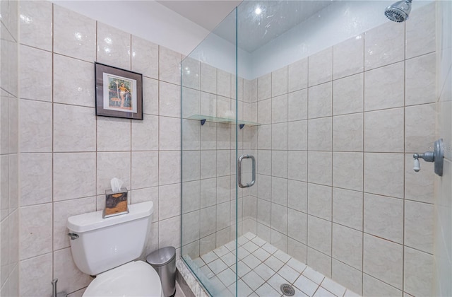 bathroom with tile walls, an enclosed shower, and toilet