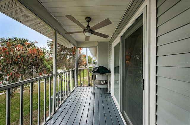 deck with a yard and ceiling fan