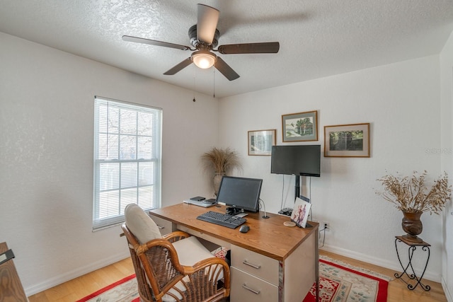 office area featuring a textured ceiling, ceiling fan, and light hardwood / wood-style flooring