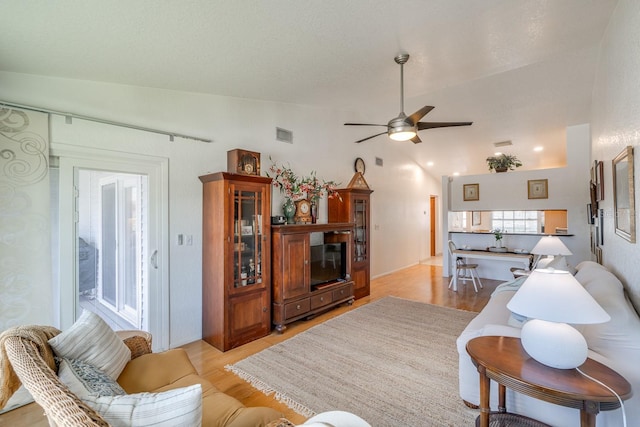 living room featuring light hardwood / wood-style floors, ceiling fan, and lofted ceiling