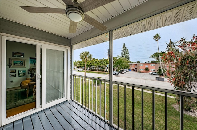 wooden terrace featuring ceiling fan and a yard