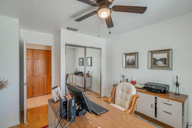 office with light wood-type flooring, a textured ceiling, and ceiling fan