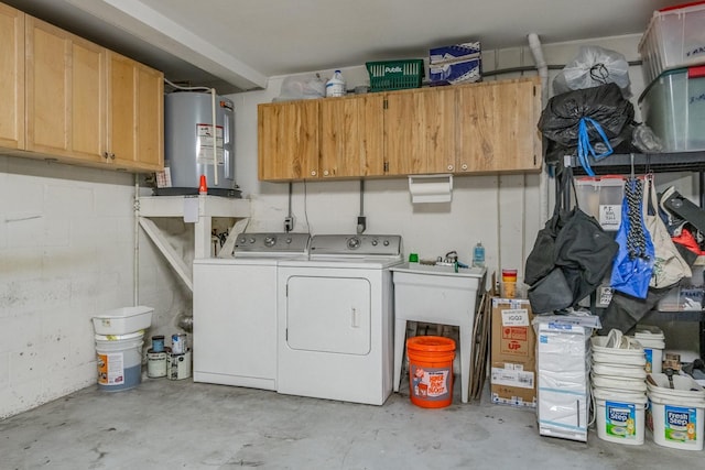 clothes washing area featuring water heater, cabinets, and washer and dryer