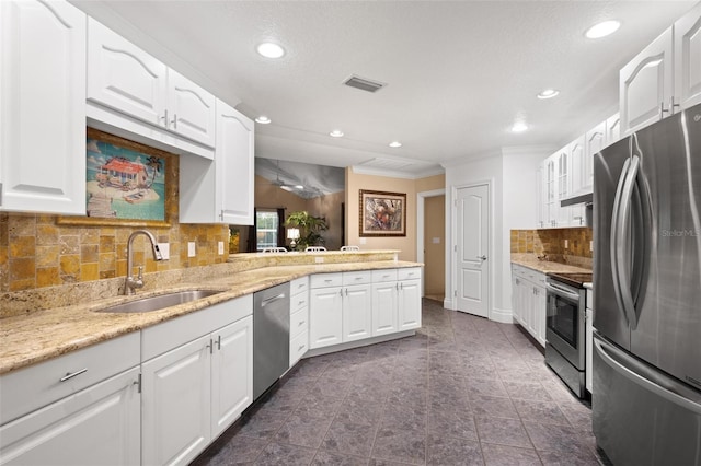 kitchen with kitchen peninsula, appliances with stainless steel finishes, white cabinets, and sink