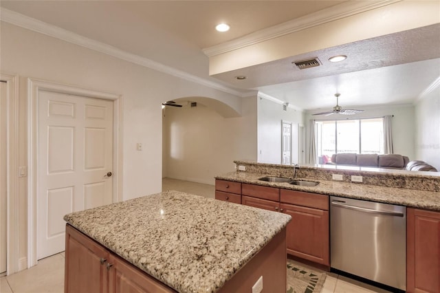 kitchen featuring a center island, light stone countertops, sink, stainless steel dishwasher, and ceiling fan