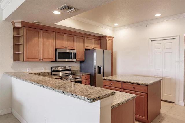 kitchen with appliances with stainless steel finishes, a center island, light tile flooring, ornamental molding, and kitchen peninsula