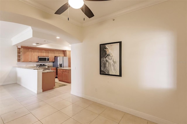 kitchen with ornamental molding, kitchen peninsula, appliances with stainless steel finishes, light tile floors, and ceiling fan