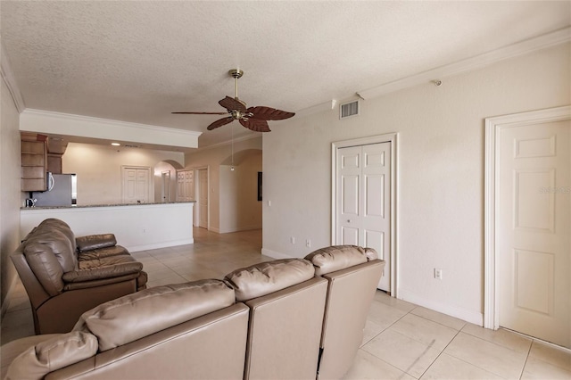 tiled living room with ornamental molding, ceiling fan, and a textured ceiling