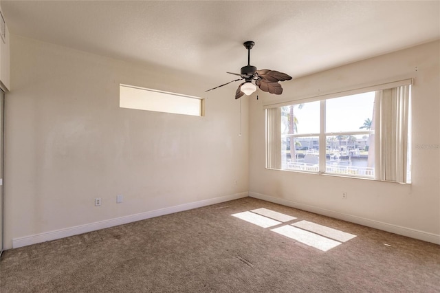 empty room featuring ceiling fan and carpet