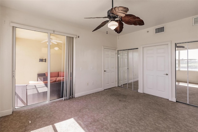 unfurnished bedroom featuring multiple closets, ceiling fan, and carpet