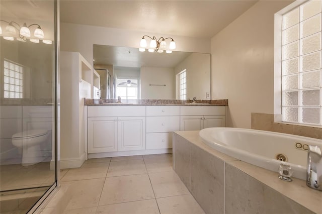 full bathroom featuring vanity with extensive cabinet space, shower with separate bathtub, toilet, and tile flooring