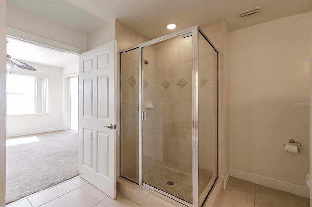 bathroom with a shower with shower door, tile floors, and ceiling fan