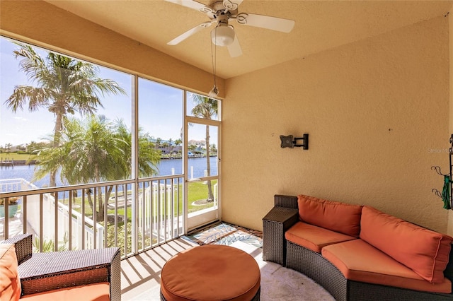 sunroom / solarium featuring plenty of natural light, ceiling fan, and a water view