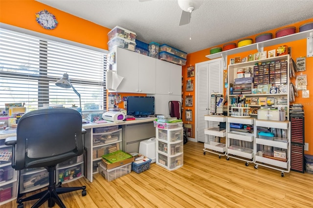 office with a textured ceiling, ceiling fan, and light wood-type flooring