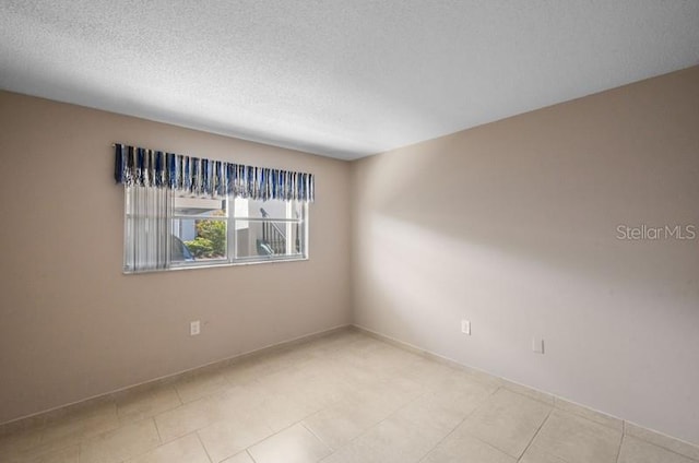 tiled spare room with a textured ceiling