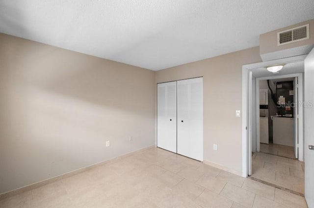 unfurnished bedroom featuring a closet and light tile floors