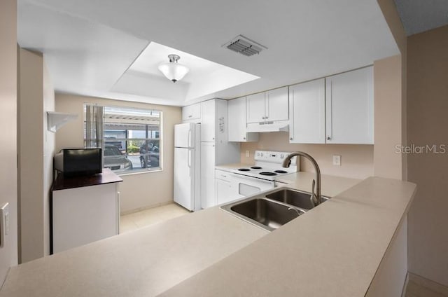 kitchen with white appliances, sink, light tile floors, a raised ceiling, and white cabinets