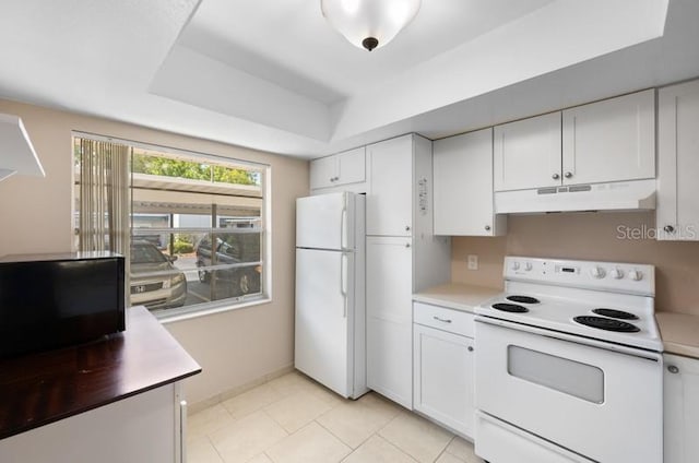 kitchen with light tile floors, a raised ceiling, white appliances, and white cabinetry